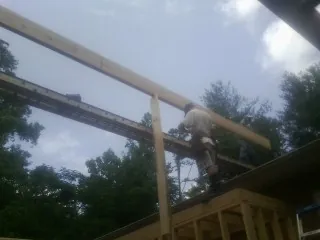 Carpenter setting a ridge beam over a new addition frame — Ice Dam Removal by Roofing Brothers in Buffalo Mills