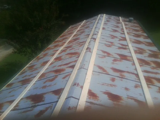 Rusted metal roof panels with new wood purlins before replacement — Storm Damage Roof Repair in Buffalo Mills by Roofing Brothers