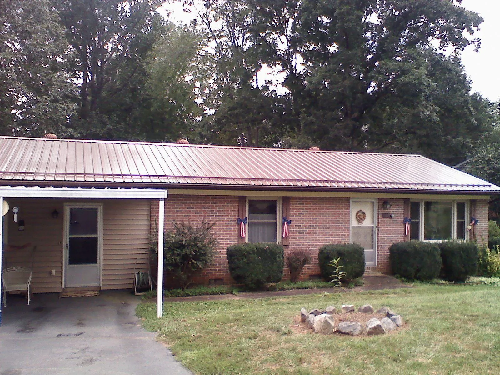 Bronze metal roof and carport on a brick ranch home — Roof Repair work by our crew in Buffalo Mills